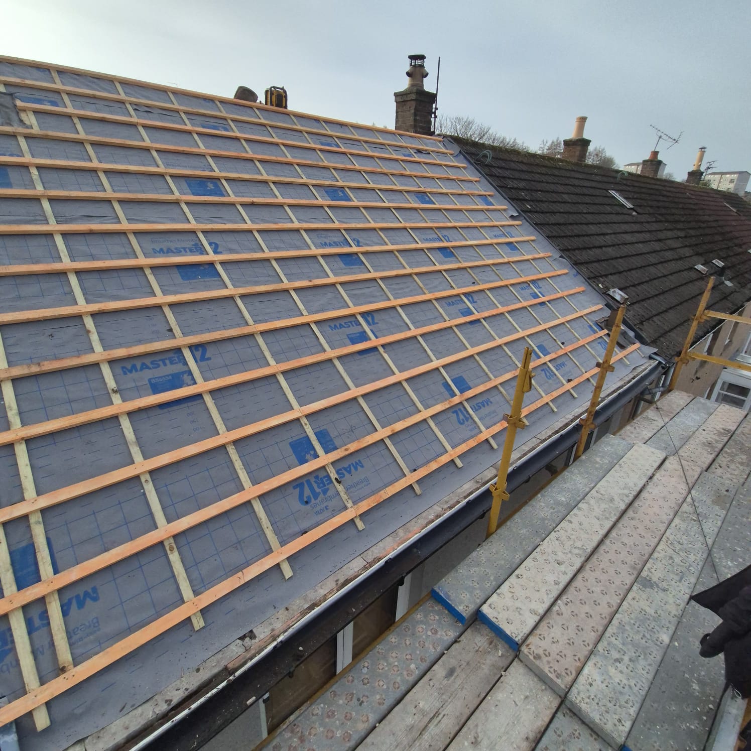 Full pitched roof replacement underway with fresh battens and slate — Rossi Roofing